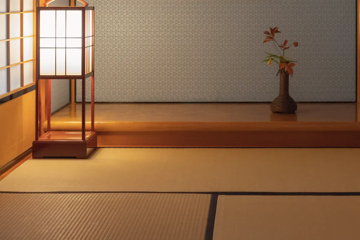 A tatami tea-room alcove with a paper lantern and a branch in a vase